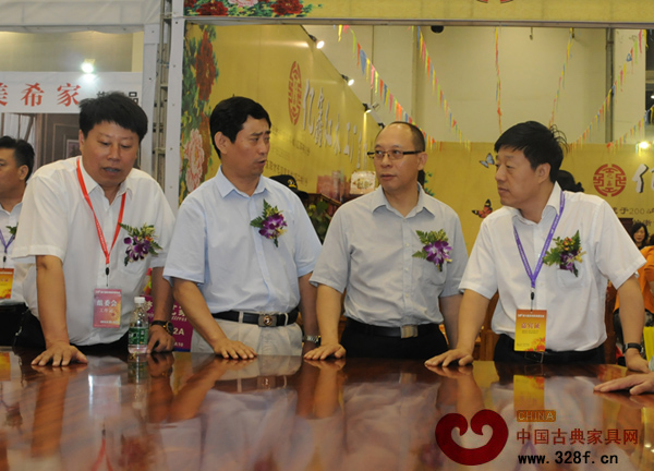 中国家具协会理事长朱长岭（左二）、副理事长陈宝光（右二）等嘉宾驻足观看红木家具 